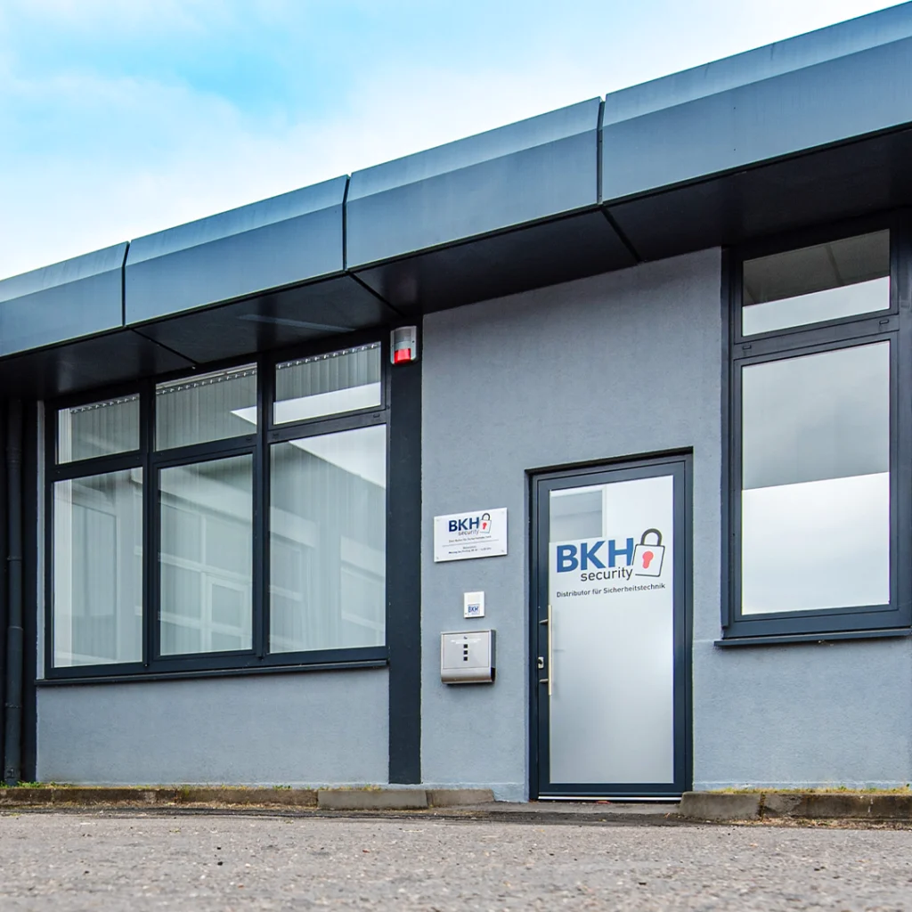 Eingang zu einem modernen Bürogebäude mit der Aufschrift "BKH security" und großen Fenstern.